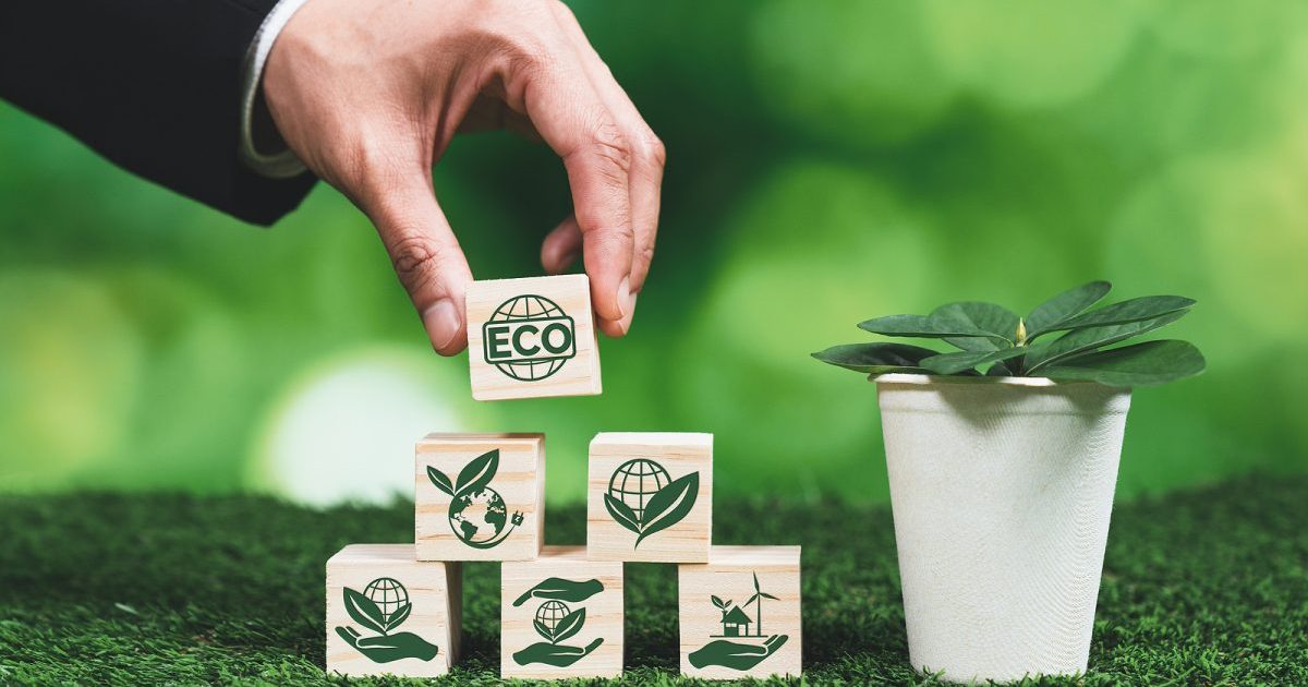 hand stacking wooden blocks with environmental icons printed on them