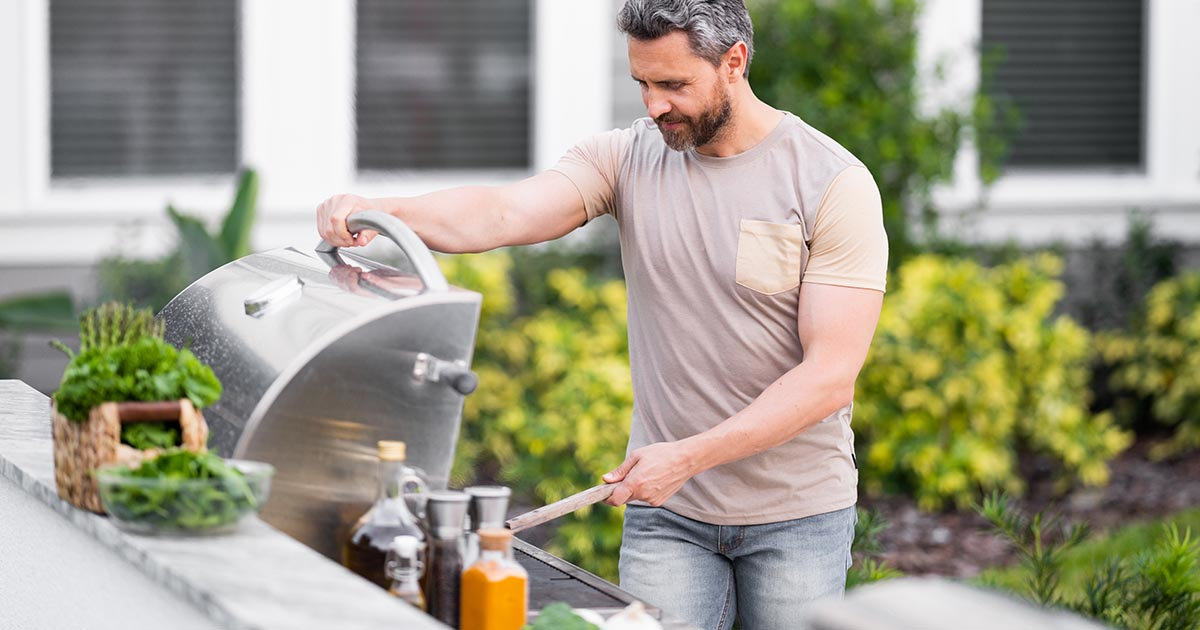 man at propane grill