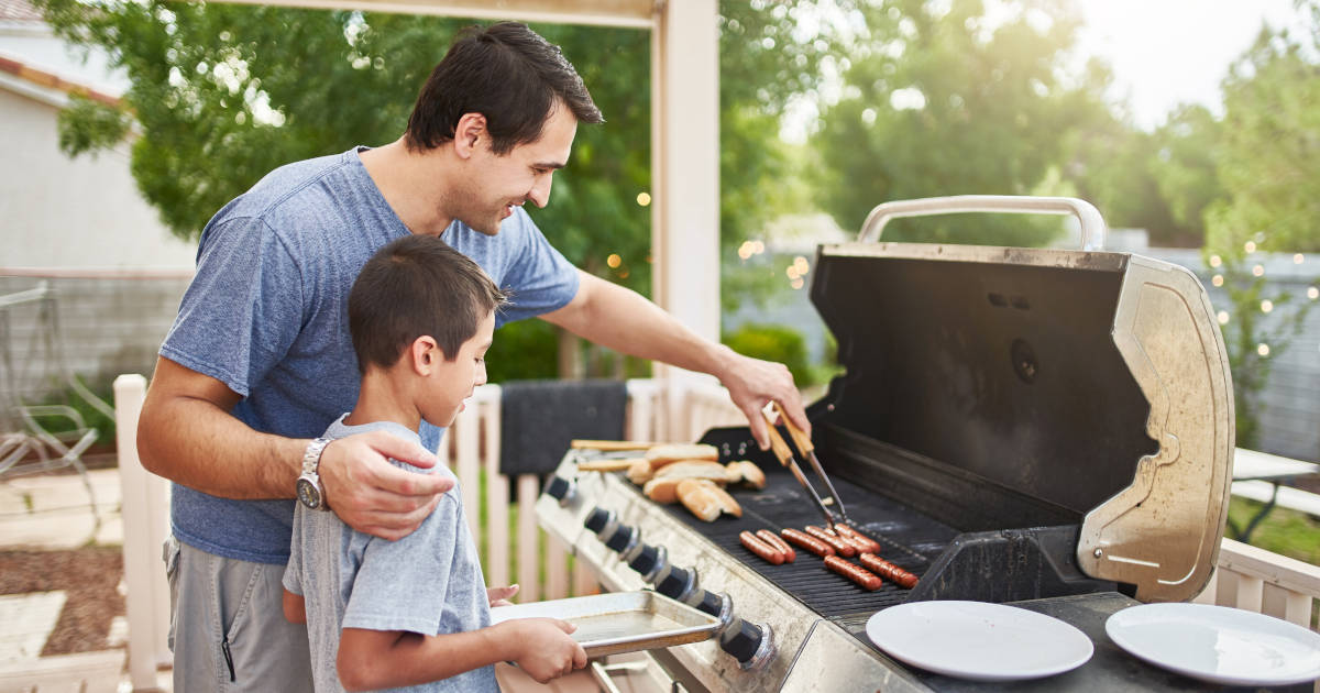 father and son using propane grill