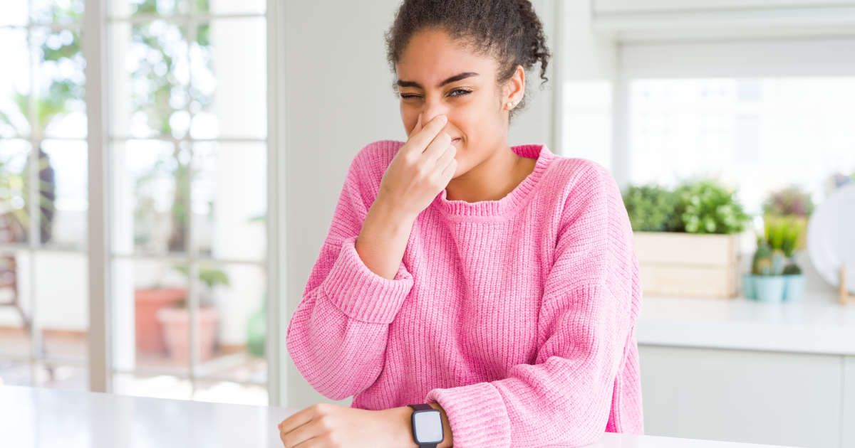 woman holding nose